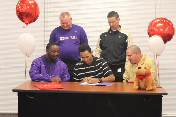 Dixon is seen signing with McPherson College