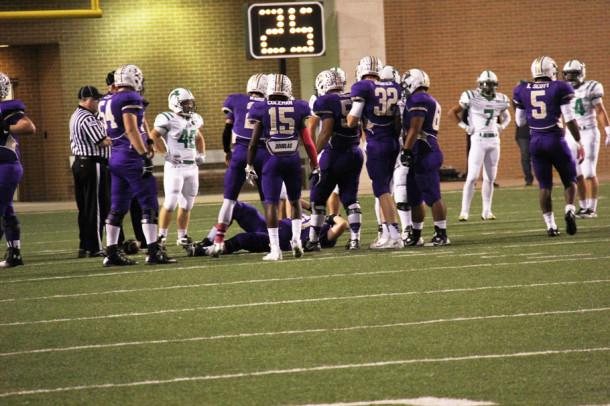 Senior Jacob Dodson is watched by his teammates as he lays motionless on the turf. Dodson left the Azle game with an injury to his left knee.