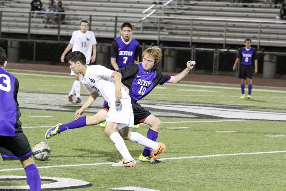 Trying to keep the ball from a defender during the Lake Dallas game is junior Zach Ardis. The Broncos won the game 2-1 to clinch the second see out of district 11-4A.