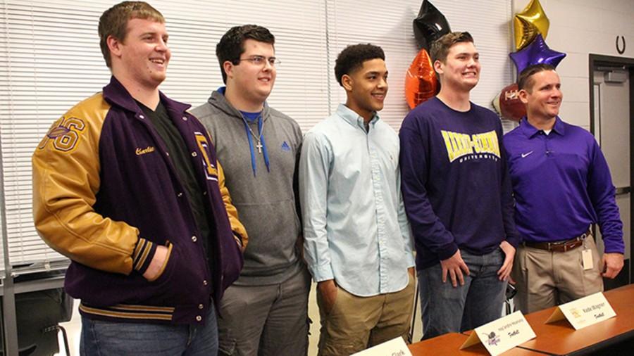 Judd Terry, Rowdy Clark, Key’andre Hearvey and Kade Wagner pose with football coach Kevin Atkinson after signing letters of intent to play football at several colleges.